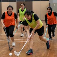 Illustration: women playing floorball indoors